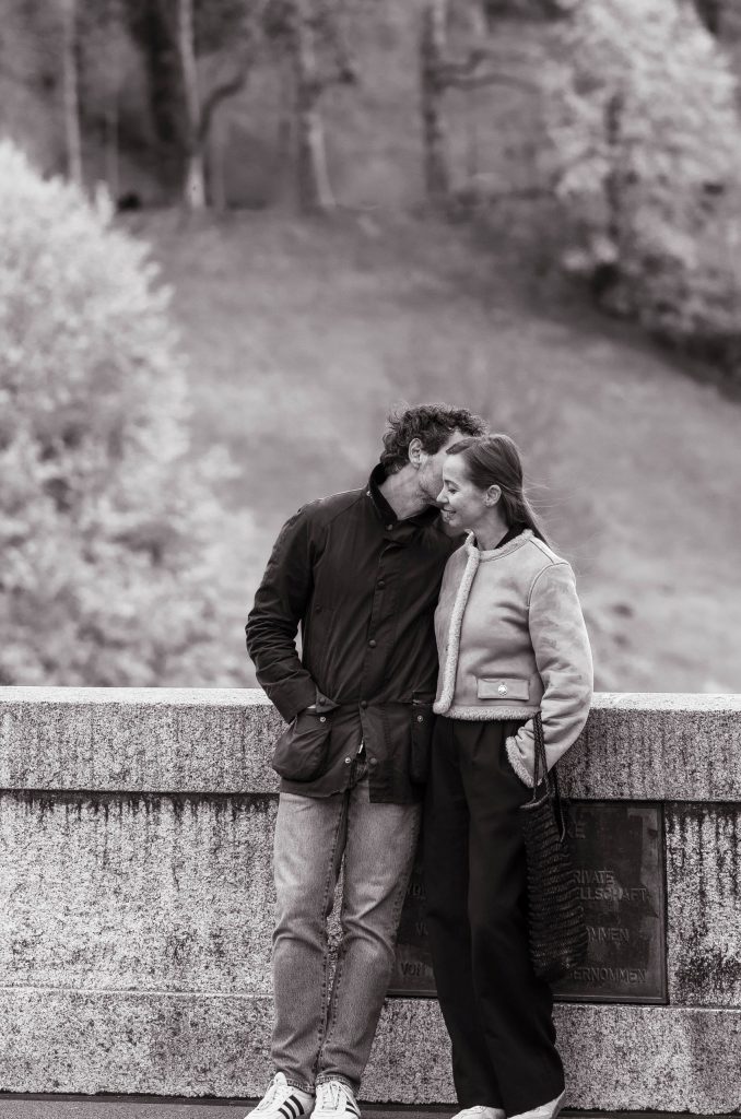 A couple cuddles on the city streets in Switzerland