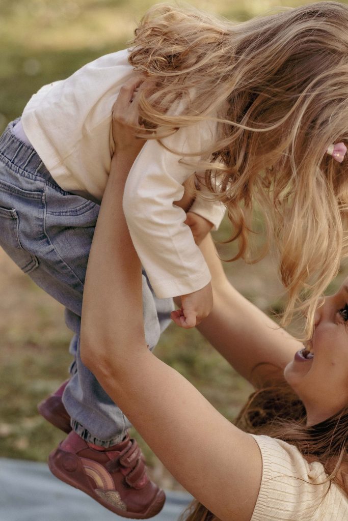 A mother lifts her little girl high in the air in the Villa dei Cedri park in Bellizona
