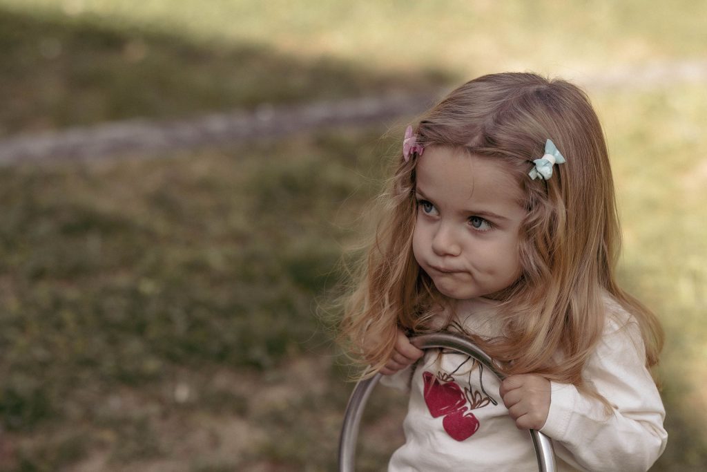 A little girl makes a funny face on the seesaw in Villa dei Cedri Park in Bellinzona