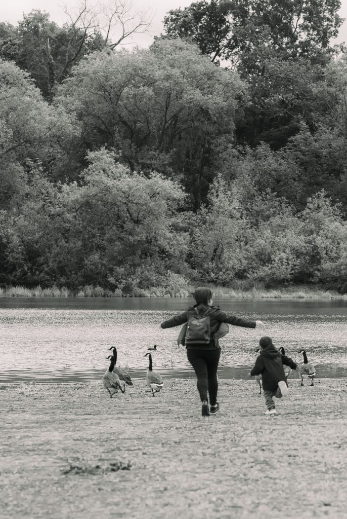 A mother is running with her son in a park in London