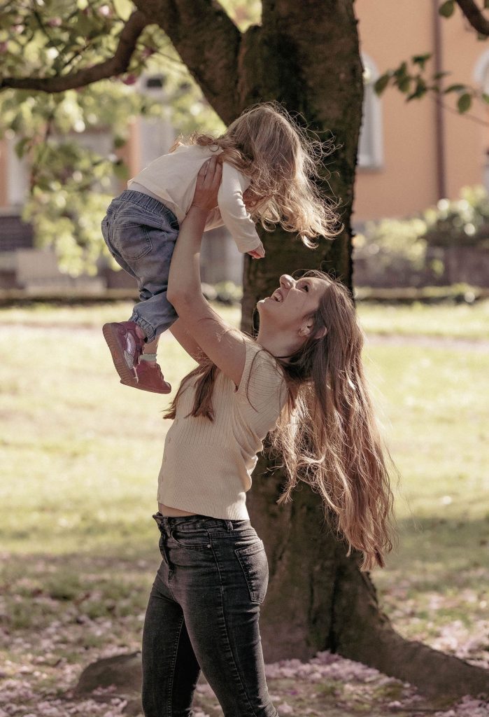 A mother lifts her little girl high in the air in the Villa dei Cedri park in Bellizona