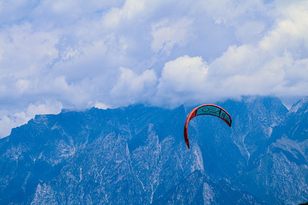 A kite can be seen in front of the mountains in Italy, at Lago di Como
