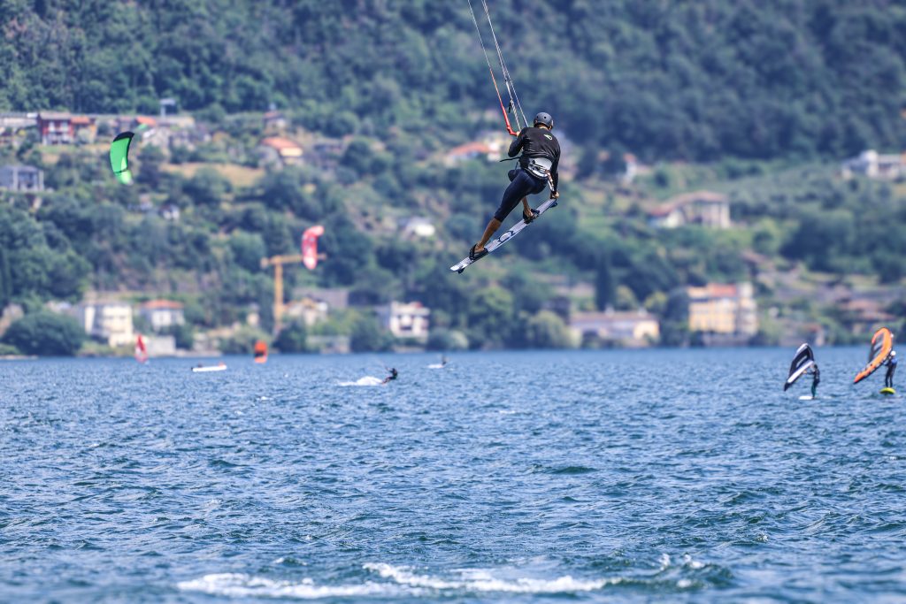 A man is kitesurfing on Lago di Como in Italy, jumping high