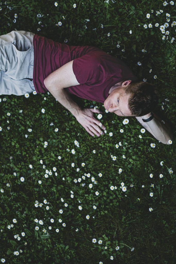 A man is lying in the grass at Castel Grande in Bellinzona