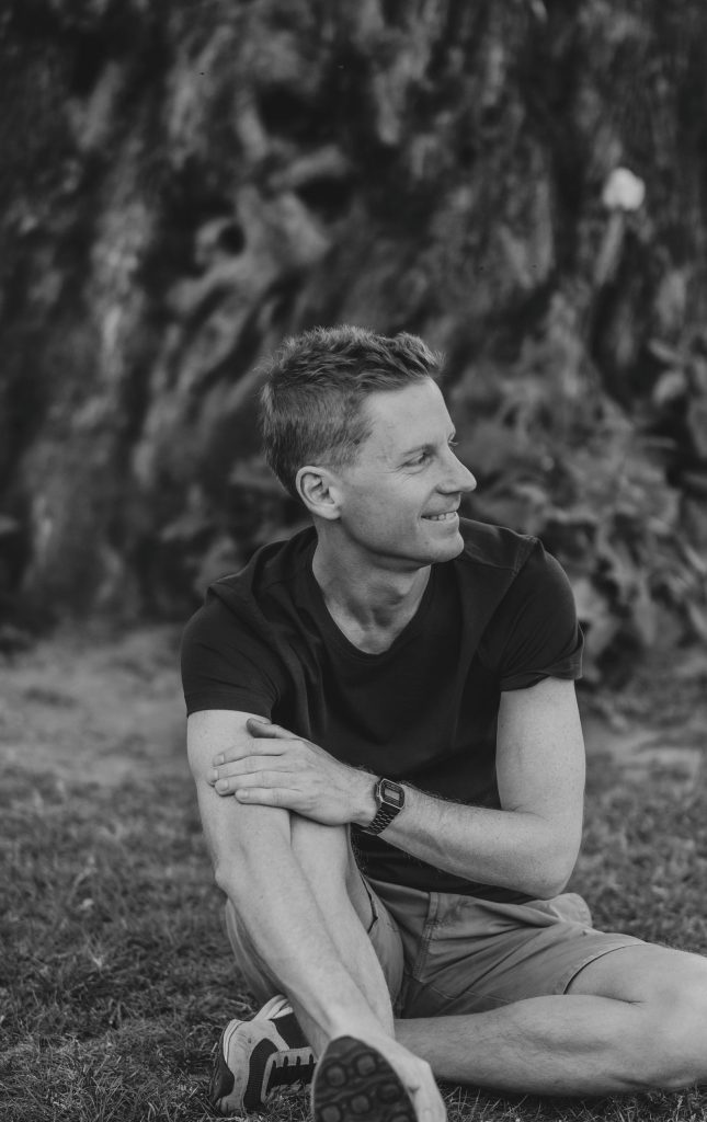 A man poses at Castel Grande, sitting on the grass in Bellinzona