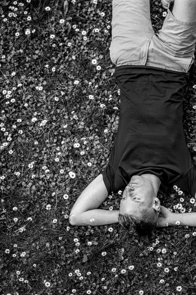 A man is lying in the grass at Castel Grande in Bellinzona