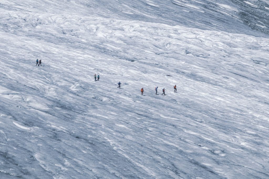 A group is hiking on a glacier in the Swiss Alps