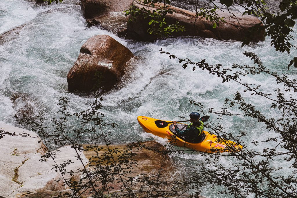 A man is rafting down a river in Ticino, Switzerland