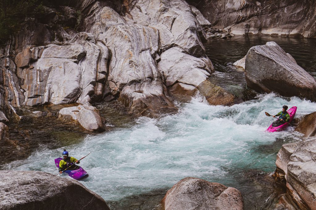Two men are rafting down a river in Ticino, Switzerland