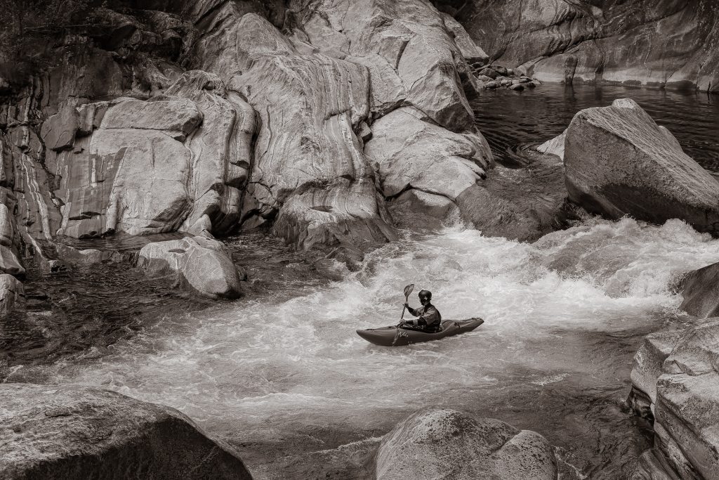 A man is rafting down a river in Ticino, Switzerland