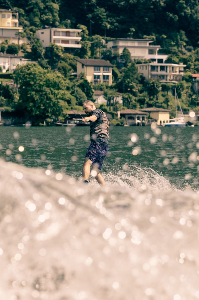 A man is wakeboarding on Lago di Lugano