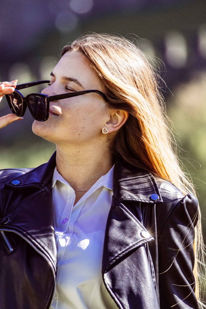 A woman touches her sunglasses with her eyes closed at Castel Grande in Bellinzona