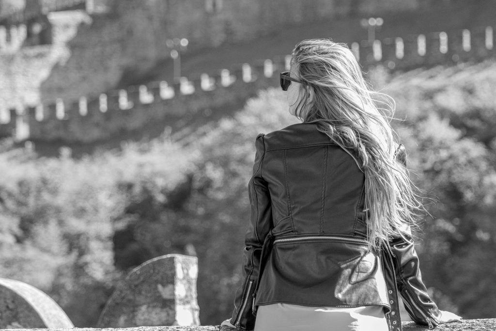 A woman leans against the castle wall at Castel Grande in Bellinzona