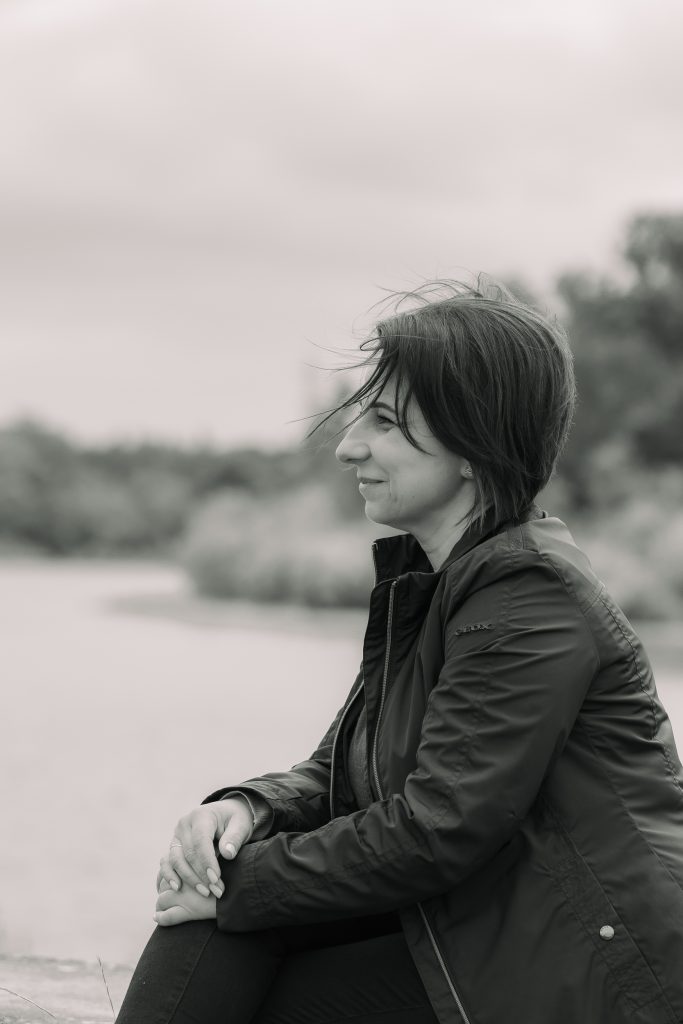 A woman is sitting in a park in London, smiling