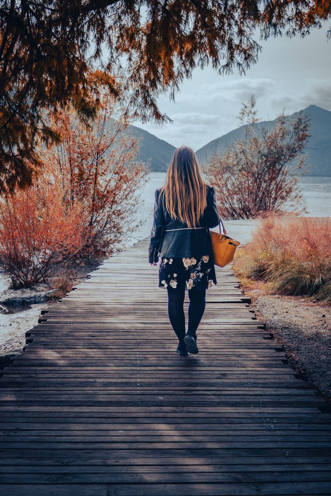 A woman is walking in Lugano along the shore of Lake Lugano in Ciani Park
